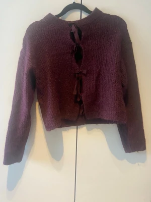 Vinröd stickad tröja med rosetter på framsidan. - Vinröd stickad tröja från Gina Tricot. Tröjan har en croppad passform och långa ärmar. Mjuk och fluffig struktur som ger en mysig känsla. Perfekt för dig som vill ha något annorlunda och trendigt.