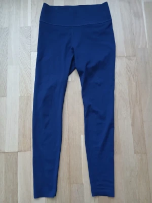 H&M Mörkblå  leggings.  - Mörkblå leggings med hög midja och bred linning. Tight passform och stretchigt material som sitter skönt på kroppen. Perfekta till både träning och chill. Inga synliga detaljer eller mönster.