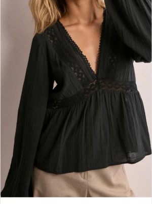 Svart blus med spetsdetaljer - Super fin topp från Nelly! Den är i super bra skick, men är lite skrynklig då den legat i en byrå. #spets #2000s #stockholm #svart #snygg #söt #nelly #gina #flare #hm