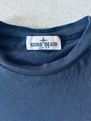 Mörkblå Stone Island Junior t-shirt - Snygg mörkblå t-shirt från Stone Island Junior med klassisk rund hals och  logo på bröstet
