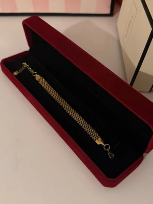 Guld Armband X-länk - Helt ny aldrig använd. Rostfritt stål. Justerbar.