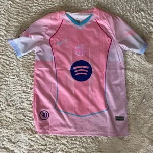 Barça Lamine Yamal rosa fotbollströja Nike S - Säljer en FC Barcelona fotbollströja i rosa och ljuslila med Lamine Yamal och nummer 10 på ryggen. Tröjan har korta ärmar, Nike-logga, Spotify och UNHCR-tryck samt UEFA Foundation-märke på ärmen. Tillverkad i lätt och ventilerande material.