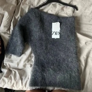Grå stickad tröja från Zara - Mysig grå stickad tröja från Zara med trekvartsärm och fluffig känsla. Helt ny, Änvänd en gång va lite för snabb att ta av lappen därför den säljs😊
