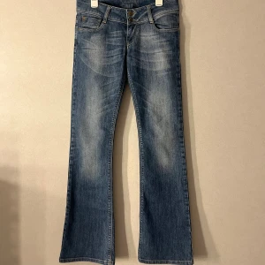 Blå bootcut jeans från Ventana, W27 L32 - Snygga blå bootcut jeans från Ventana med klassisk femficksdesign. Jeansen har låg midja och är tillverkade i en bomullsblandning med stretch för skön passform. Perfekta för dig som gillar en tidlös och avslappnad look. Storlek S. Pris kan diskuteras🤗