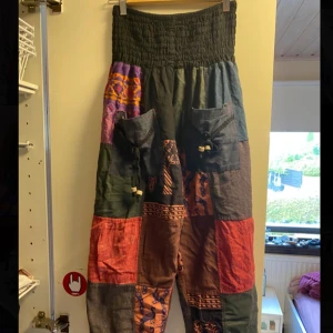 Hippie byxor i bomull - Färgglada hippie/boho byxor i 100% bomull. Byxorna har midja med resår och fickor framtill. Köpte dem för 350 kr och har endast använt en gång. Passar både S och M