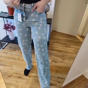 Bikbok jeans med blommigt print - 90s Straight jeans från Bikbok. Blommigt print över hela jeansen. Storlek midja 27, längd 32. Gjorda av 100% bomull. Helt nya med lapparna kvar! Nypriset är 599kr.