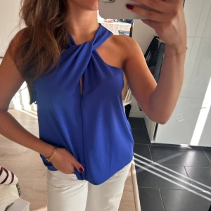 halterneck topp - Säljer halterneck topp och liten slits framtill vid halsen