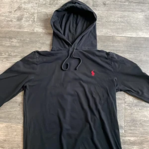 Ralph Lauren hoodie - Säljer denna feta hoodien från märket Polo Raulph Lauren. Hoodien är svart med röd logga på bröstet. Storlek XS och skick 9/10.
