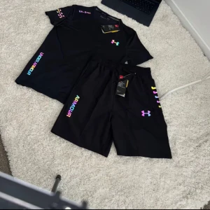 Svarta Under Armour reflective set(HAR ÄVEN SIZE M) - Svart under armour set från Under Armour med coola reflekterande loggor och detaljer. Setet har är gjorda i ett lätt och funktionellt syntetmaterial som andas. Perfekta för gymmet eller löprundan. Om ni är osäkra på om den kmr passa dig så kan du fråga mig.