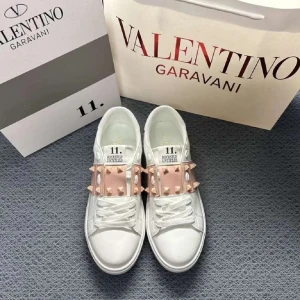 Valentino Rockstud vita sneakers - Storlek 38. Snygga vita Valentino Rockstud sneakers i skinn med ljusrosa band över vristen dekorerat med ikoniska nitar. Klassisk rund tå, platt sula och vita snören. Perfekta för dig som vill sticka ut med exklusiv streetstyle. hör av er för mer info eller bilder använda 1 gång