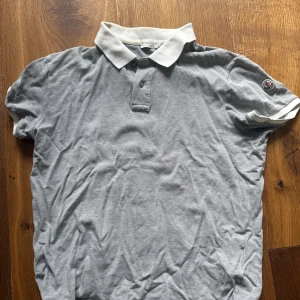 Grå Moncler piké - Säljer nu en fet grå moncler piké. Tvär fet med loggan på armen och moncler text under kragen om man vill ha den i sport! Såklart äkta och priset är inte hugget i sten. Perfekt skick förutom att den kan behöva en strykning! Storleken säger L men jag skulle nog tippa på att den är mer som en M storlek.