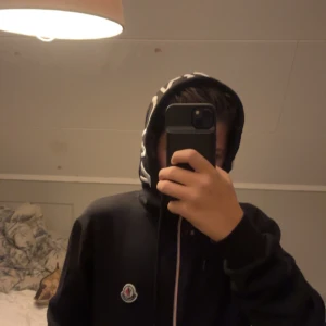 Svart mjukis sett från Moncler - Svarta mjukisbyxor från Moncler med klassisk logga på benet. Byxorna har en relaxed passform och är tillverkade i mjukt bomullsmaterial. Perfekta för chill dagar och streetwear-stil. Snygga detaljer med dragsko i midjan och diskret broderad logotyp.