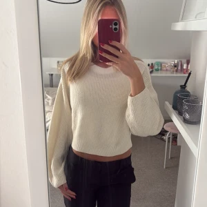 Vit croppad stickad tröja - Säljer en vit croppad stickad tröja med rund hals och långa ärmar. 
