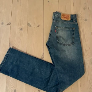 Levi's 511 slim - Klassiska Levi's 511 jeans i blå denim. Jeansen har fem fickor, knappgylf och den ikoniska läderpatchen bak i midjan. Snyggt slitna detaljer och den typiska röda Levi's-taggen på bakfickan. Storlek  W30 L34. Hör av dig vid fundering!