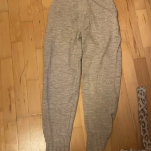 Beige stickad hoodie och stickade byxor. - Mysig beige stickad hoodie och  byxor från Lindex i storlek 134/140. Tröjan har huva och långa ärmar. Byxorna är mjuka och man kan knyta dem längst upp.