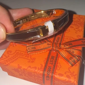 Harmens Click H armband svart/guld  - Snyggt armband från Harmens  i svart och guld. Armbandet har en stilren, blank finish och klassisk H-detalj framtill. Perfekt accessoar för att lyfta din outfit med en lyxig touch. Kommer i  box, nytt samt rostfritt samt vattentåligt 