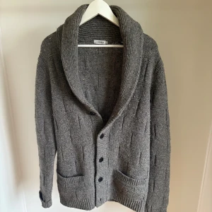 Grå stickad cardigan från J.Lindeberg - En schysst cardigan från J lindeberg i storlek L. Säljs för 590 kronor. 