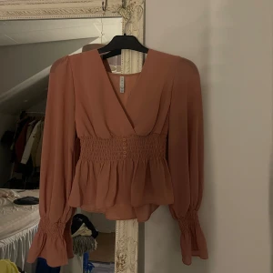 Rosa blus från AMISU - Supersöt rostrosa blus med omlott och v-ringning. Använt endast 1 gång 