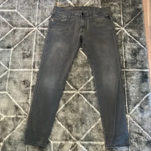 Grå Replay jeans slim fit, kan också bytas mot nått! - Säljer ett par grå jeans från Replay i slim fit-modell. Byxorna har klassisk femficksdesign, svarta detaljer och snygg Replay-logga vid fickan. Jeansen är tillverkade i ett mjukt bomullsmaterial med lite stretch för extra komfort.
