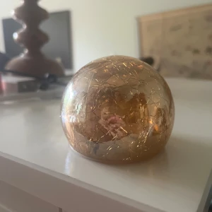 Glittrig rund guldfärgad lampa - Säljer en rund och glittrig lampa i guldfärg med spräckligt mönster. Perfekt som dekorativt inslag. . Kulan har en cool, glansig yta som reflekterar ljuset snyggt.