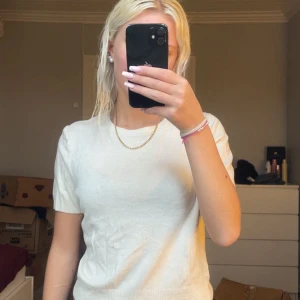 Beige t-shirt från DIVIDED, strl M - Snygg beige t-shirt från DIVIDED i storlek M. Modellen har rund hals och korta ärmar, tillverkad i mjuk bomull som känns skön mot huden. Enkel och clean design som funkar till många olika stilar. Perfekt för dig som gillar neutrala färger.