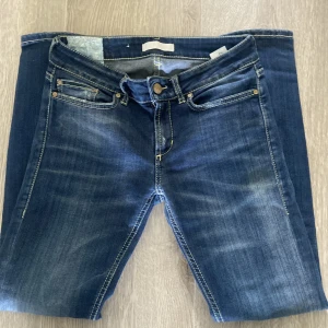 Blå jeans från Dondup, storlek 27 - Snygga blå jeans från Dondup i klassisk femficksmodell med läderpatch där bak. Jeansen har en rak passform och är tillverkade i mjukt denimtyg. Perfekta för dig som gillar en tidlös look med coola detaljer.