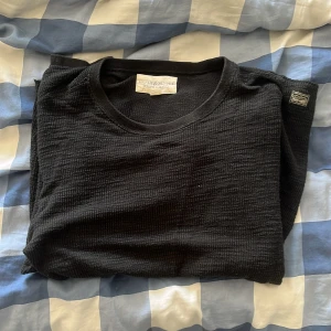 Svart stickad tröja från Ralph Lauren - Svart tvär fet stickad tröja från Denim & Supply Ralph Lauren. Tröjan har en klassisk rund halsringning. Lite tjockare så är perfekt för lager-på-lager och chill stil. Passar dig som gillar enkel men snygg design.