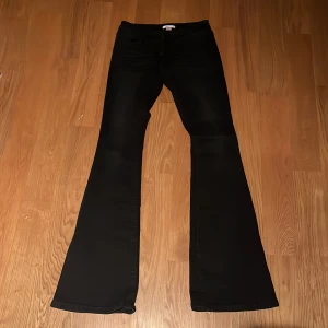 Svarta bootcut jeans från Gina Tricot - NYA, ALDRIG ANVÄNDA. Säljer ett par svarta bootcut jeans från Gina Tricot i storlek S 14+. Byxorna har snygga detaljer med små silvriga nitar på bakfickorna och klassisk femficksmodell. Perfekta för dig som gillar en lite utsvängd look och vill sticka ut lite extra.