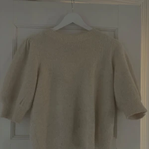 Beige stickad tröja från Vero Moda - Supermysig beige stickad tröja från Vero Moda med puffiga halvlånga ärmar och ribbade muddar. Perfekt för lager på lager och passar till både jeans och kjol. Enkel och stilren design som funkar året runt.