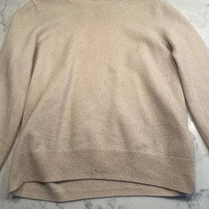 Beige kashmirtröja från H&M XS - Supermjuk och stilren beige tröja i 100% kashmir från H&M. Klassisk modell med rund hals och ribbade muddar. Perfekt för dig som gillar en enkel och clean look. Passar till allt och är riktigt skön att ha på sig.