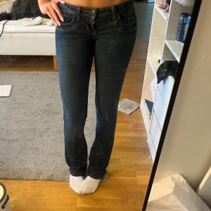 Mörkblå bootcut jeans från LTB  - Säljer ett par mörkblå jeans från LTB. De har låg midja och bootcut-ben, klassisk femficksdesign och snygga kontrastsömmar. Jeansen är i stretchigt denim och passar perfekt till en avslappnad stil.