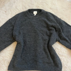 Mörkgrå stickad tröja H&M - Mysig mörkgrå stickad tröja från H&M med rund halsringning och långa ärmar. Perfekt för lager-på-lager och chill dagar. Enkel och stilren design som funkar till det mesta. I nyskick!!!