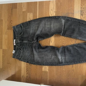 Levi's 505 svarta jeans straight fit - Säljer ett par svarta Levi's 505 jeans med straight fit. Jeansen har klassisk femficksdesign, normal midja och snyggt tvättad finish med slitningar. Perfekta för dig som gillar en avslappnad och tidlös look.