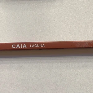 CAIA Laguna läppenna nude - Den är i full längd! Snygg läppenna från CAIA i färgen Laguna, perfekt för att definiera och forma läpparna. Pennan har en mjuk nude-brun ton som passar till många olika looks. Smidig och lätt att applicera med klassisk pennform och plastlock.