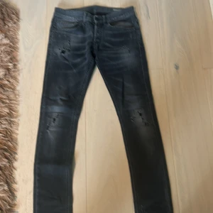 Svarta skinny jeans med slitningar - Snygga svarta skinny jeans med slitningar på låren och knäna. Jeansen har en tvättad look och klassiska fem fickor. Perfekta för dig som gillar en lite tuffare stil. Materialet är stretchigt för extra komfort.
