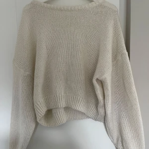Beige stickad oversized tröja - Supermysig beige stickad tröja med oversized passform och långa ärmar. Tröjan har bred ribbad kant vid hals, ärmslut och nederkant.