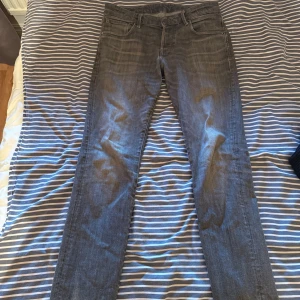 Grå jeansbyxor i rak modell, 32/34 - Snygga grå  jack and Jones jeansbyxor i rak passform med klassisk femficksdesign. Jeansen har en diskret tvättad look och är tillverkade i mjukt denimtyg. Perfekta för dig som gillar en stilren och enkel vibe till vardags.