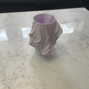 Plats vas  - Bilderna visar en skulptural vas i vit plast med organiska, vågiga former. Objektet är 15x15 cm storlek och är perfekt för hemmet och den går inte sönder lätt efter som den är gjord av plast säljer den för 50kr 