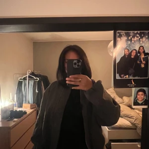 Zara Mörkgrå oversized bomberjacka - Säljer en mörkgrå bomberjacka med oversized passform och långa ärmar. Jackan har dragkedja framtill, ribbad krage och muddar samt fickor på sidorna och en extra ficka med dragkedja på ärmen. Perfekt för dig som gillar streetstyle och vill ha en chill look.