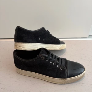 Lanvin - Lanvin Cap Toe Sneaker Black (UK 8/EU 42), mindre flaws på båda caps, annars varsamt använda, dustbags och box medföljer.