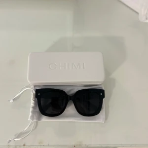 Svarta solglasögon från CHIMI - Snygga, knappt använda svarta solglasögon från CHIMI med bred, fyrkantig båge och mörka glas. Klassisk och stilren design som passar perfekt till alla outfits. Kommer med vit CHIMI-fodral och tygpåse.