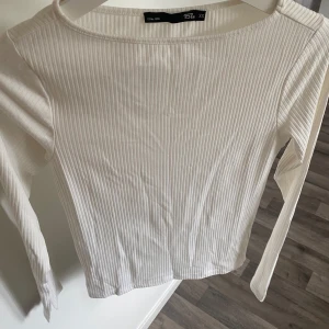 Vit ribbad långärmad topp XS - Säljer en stilren vit långärmad topp från 157 i storlek XS. Toppen är ribbad med smala vertikala ränder och har en klassisk rund halsringning. Perfekt att matcha med jeans eller kjol för en clean look.