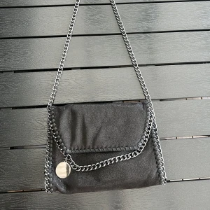 Svart axelväska med kedja - Axelväska knappt använd. Säljer för jag inte har användning till den. Skriv bara om du har frågor eller mer bilder. Pris går att diskuteras.💕