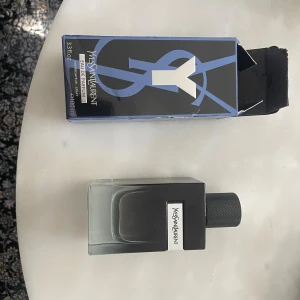 Yves Saint Laurent Y Eau de Parfum 100ml - Yves Saint Laurent Y Eau de Parfum 100ml med stilren, fyrkantig glasflaska i svart och transparent design. Snyggt YSL-märke på flaskan och svart lock med silverdetalj. Kommer med original blå och svart kartong. Helt ny och oanvända, kvitto finns om det behövs 