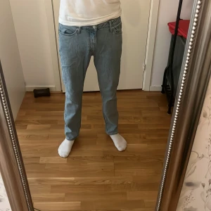 Ljusblå raka jeans - Säljer ett par ljusblå jeans med klassisk femficksdesign och rak passform. Jeansen har normal midja och är tillverkade i mjukt denimtyg. Perfekta för dig som gillar en enkel och clean look. Snygga att matcha med sneakers eller boots. Har en liten fläck färg på 4 bilden. Storlek 30-32