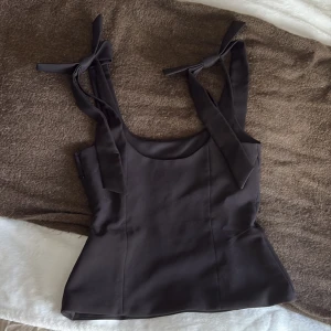 Svart korsett-topp med knytband från Zara - Säljer denna jätte fina toppen från Zara!!                 Den är i storleken S och i jätte bra skick, inga defekter eller fläckar💗 