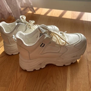 Chunky vita sneakers - Säljer ett par chunky vita sneakers från Fengdu Sport med kraftig platåsula och snörning. Skorna har en sportig vibe med detaljerade sömmar och perforeringar framtill. 