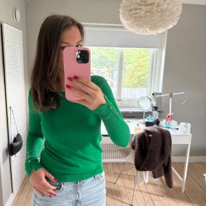 Grön långärmad tröja från Zara - Snygg grön långärmad tröja från Zara med rund hals och guldfärgade knappar vid ärmsluten. Tröjan har en slim passform och är tillverkad i mjukt material som känns skönt mot huden. Perfekt nu till hösten🍁