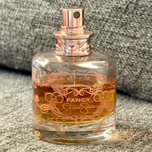 Fancy by Jessica Simpson 50 ml - Jessica Simpson Fancy, 50 ml. Kvarvarande mängd syns på bild. Givetvis förvarad mörkt och svalt. 