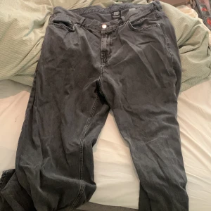 Grå jeans från Sweet Sktbs - Säljer ett par grå jeans från Sweet Sktbs med broderad logga vid fickan och klassisk femficksdesign. Jeansen har rak passform och är tillverkade i bomull. Perfekta för dig som gillar en avslappnad streetstil.